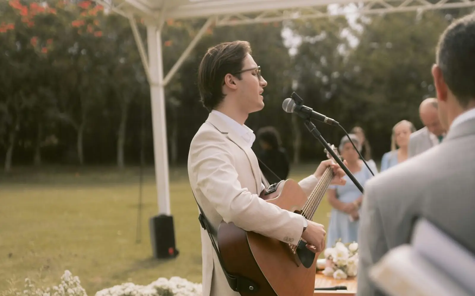 Musiker singt mit Gitarre bei einer freien Trauung im Freien